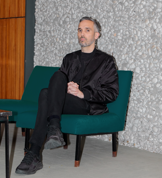 A portrait image of the artist Wesley Goatley sitting on a chair